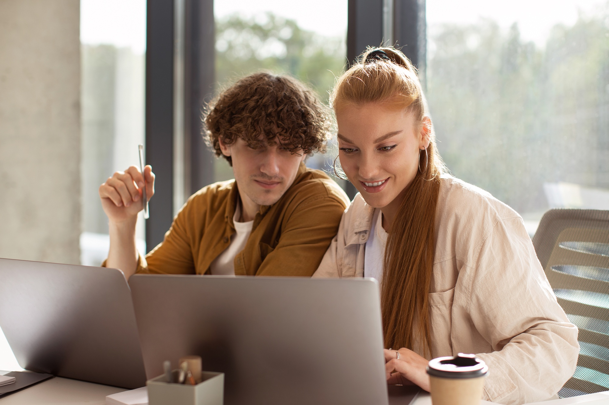 A man and a woman using laptops